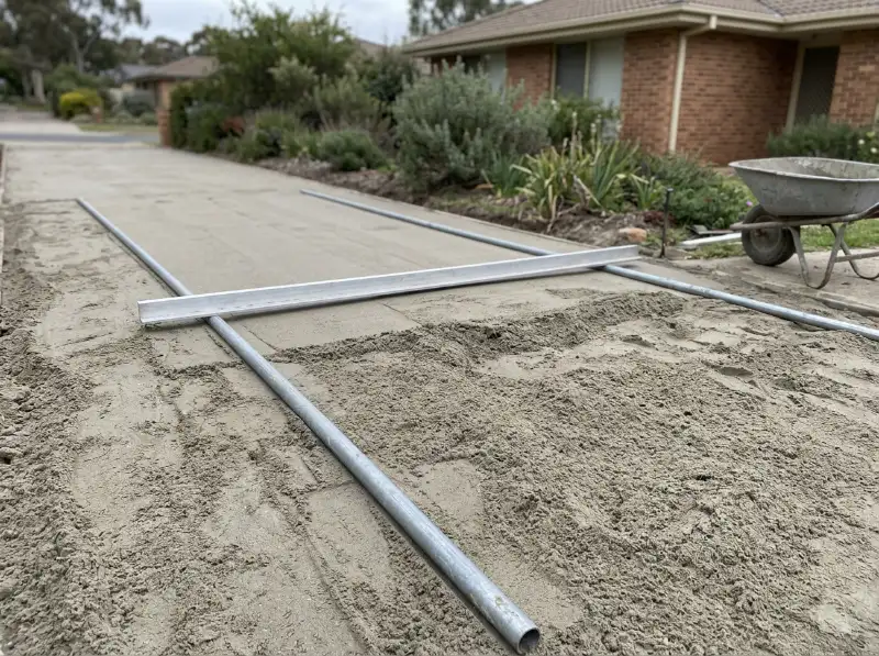 Aluminium screed rail on steel screed pipes over bedding sand, half screeded flat