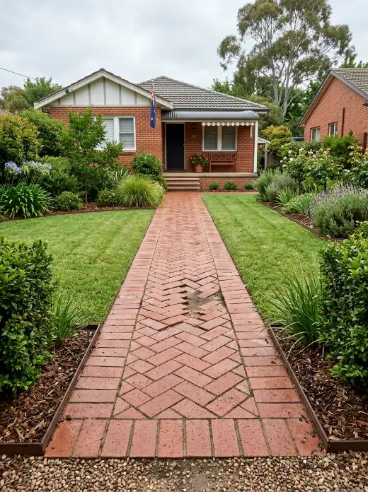 Red clay paver front path in herringbone with a few sunken, uneven pavers in the middle